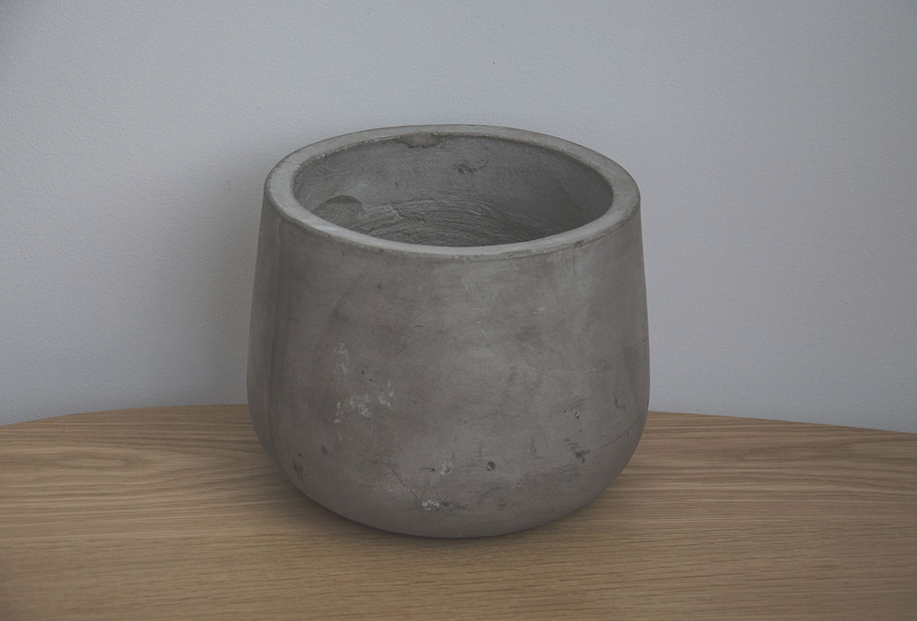 Duży betonowy wazon lub pojemnik o gładkiej strukturze.